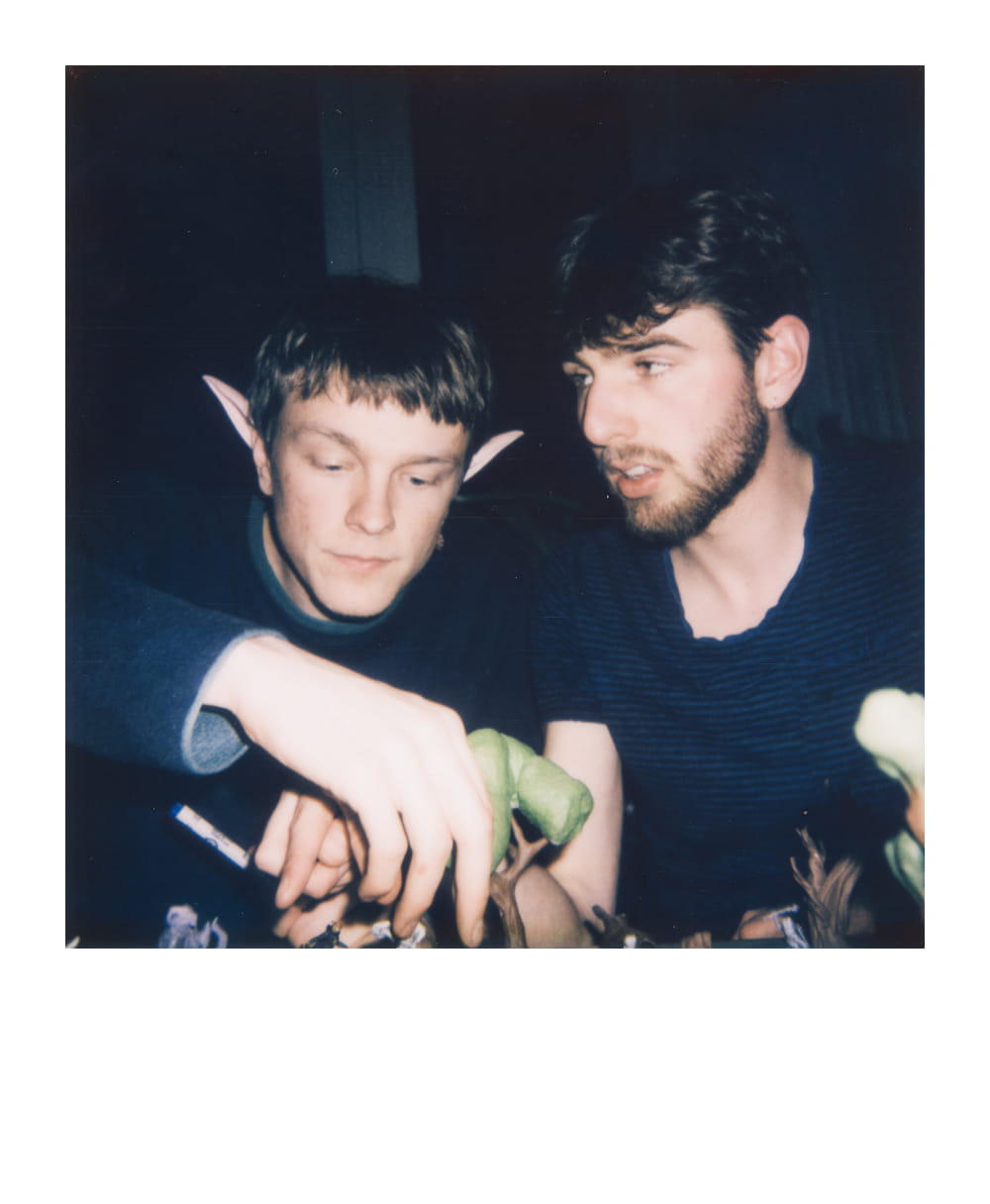 Two players immersed in moving 3d printed d&d miniatures on a game board.