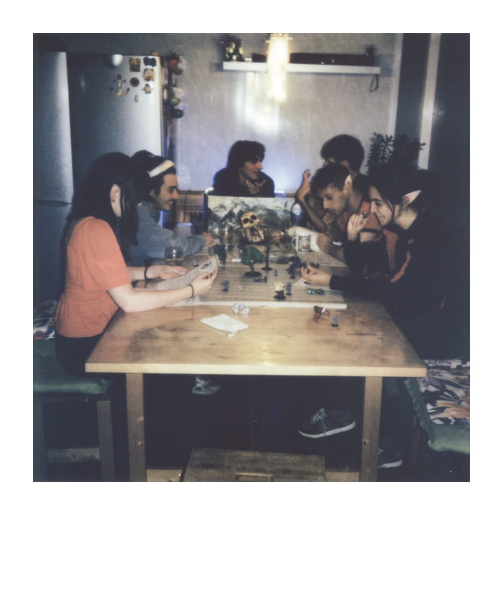 Large group playing Dungeons & Dragons at home with miniatures and a dungeon master screen